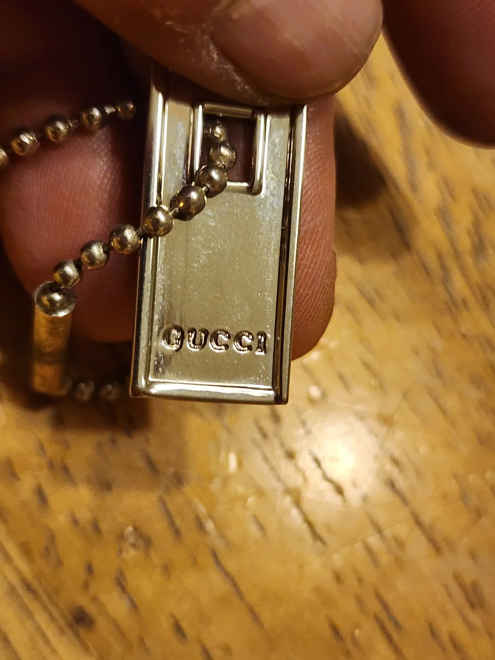 Gucci Sterling Silver Logo Tag likely used on a bracelet or keychain